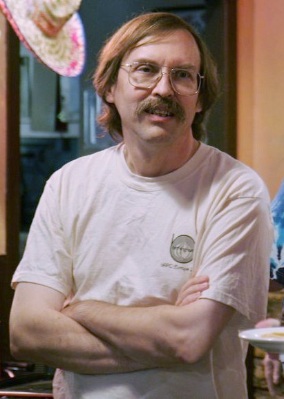 Larry Wall with a big mustache and glasses before a convention